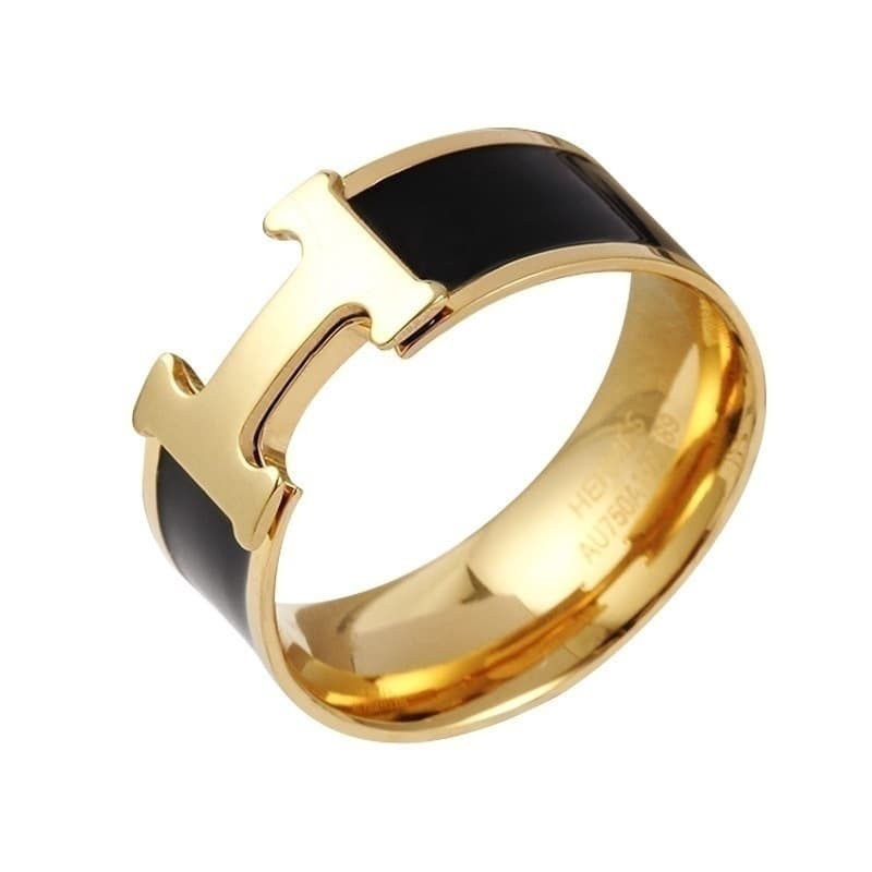 Bague élégante noire et or avec un détail en T distinctif pour un style moderne