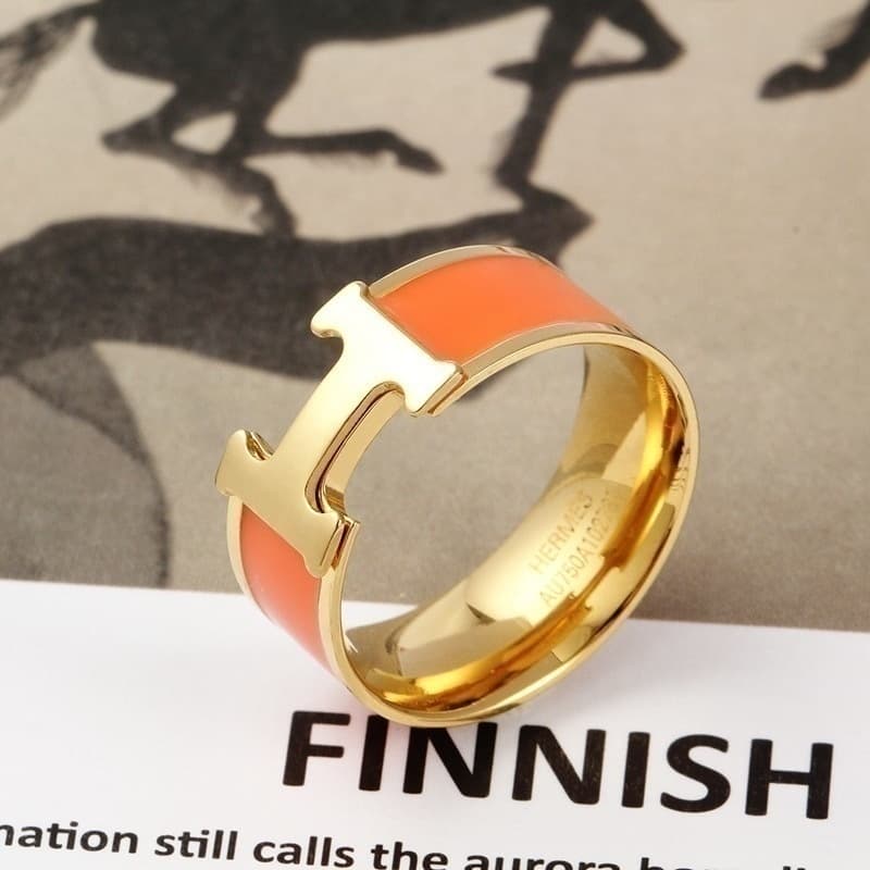 Bague élégante noire et or avec un détail en T distinctif pour un style moderne