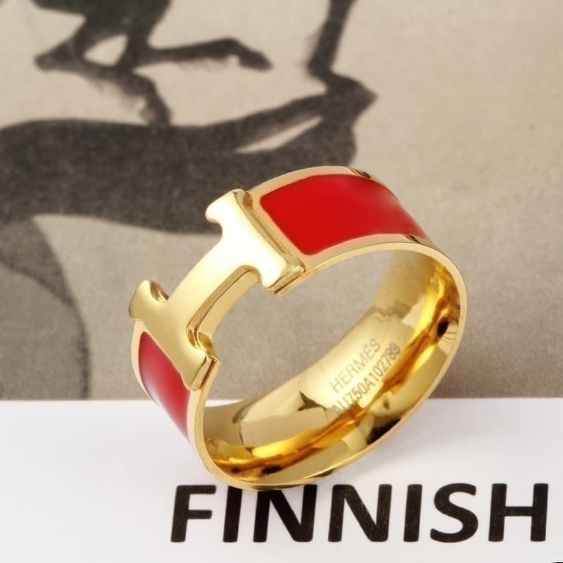 Bague élégante noire et or avec un détail en T distinctif pour un style moderne