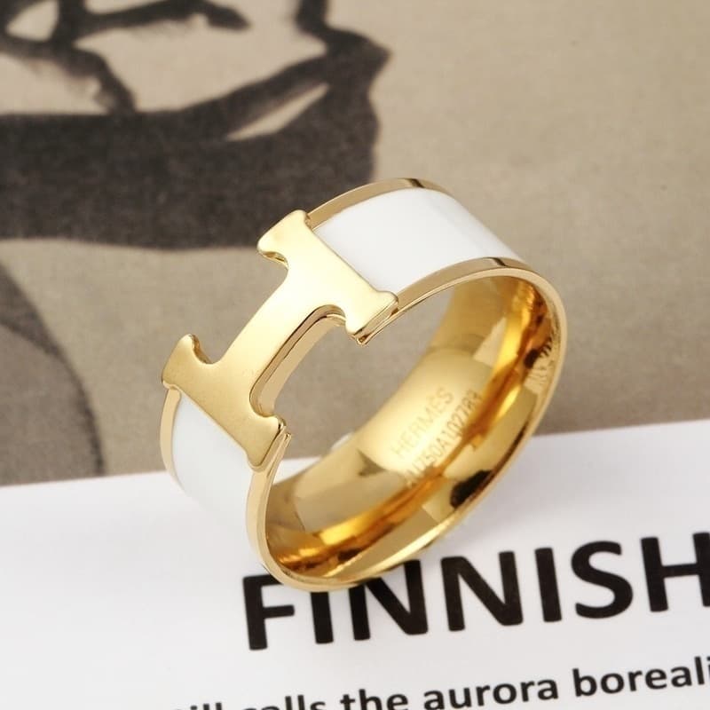 Bague élégante noire et or avec un détail en T distinctif pour un style moderne