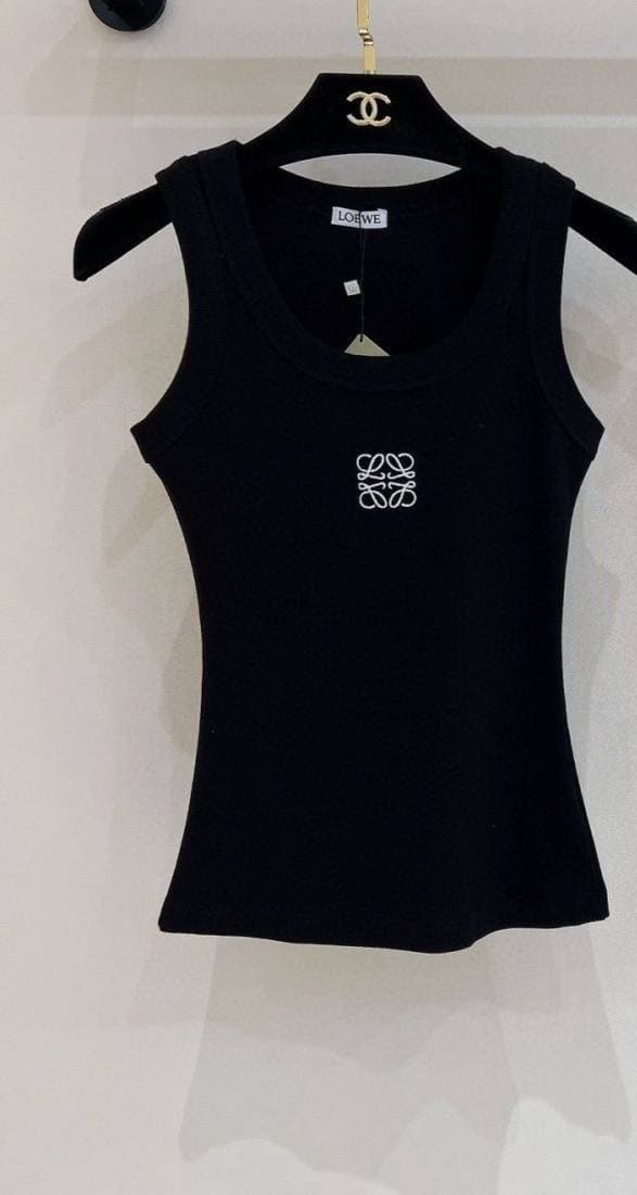 Gilet triangle printemps-été 2026 pour femme, 100% coton, coupe classique et ajustée, orné de détails métalliques.