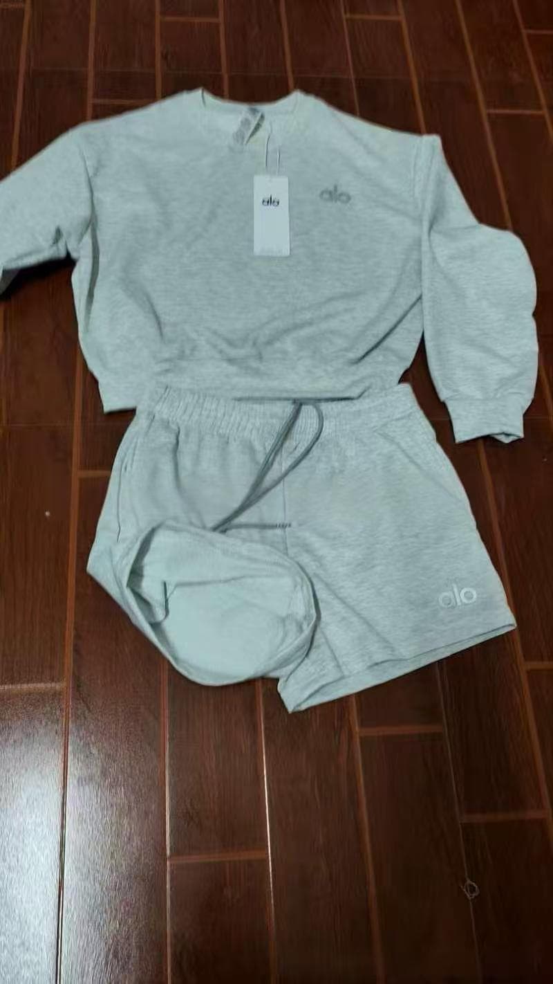 Ensemble coordonné pour femme en tissu doux rouge, composé d'un crop top à imprimé broderie Alo et d'un short décontracté à taille élastique.