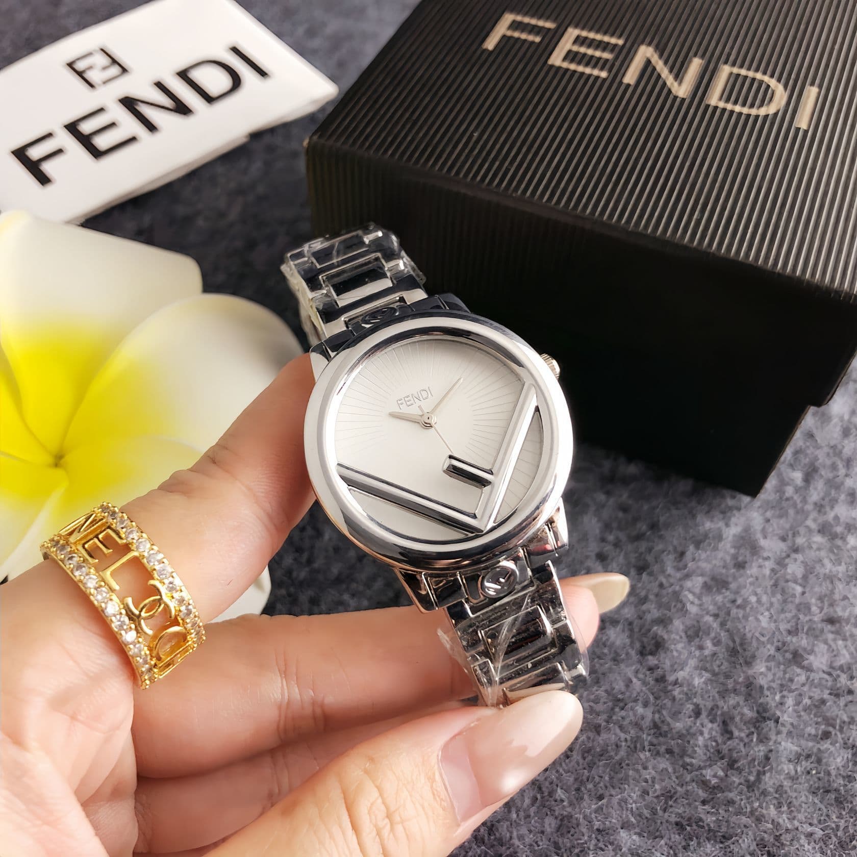 Montre pour femme compacte et élégante, ornée de la lettre « F » sur un cadran rond stylé à finition dorée