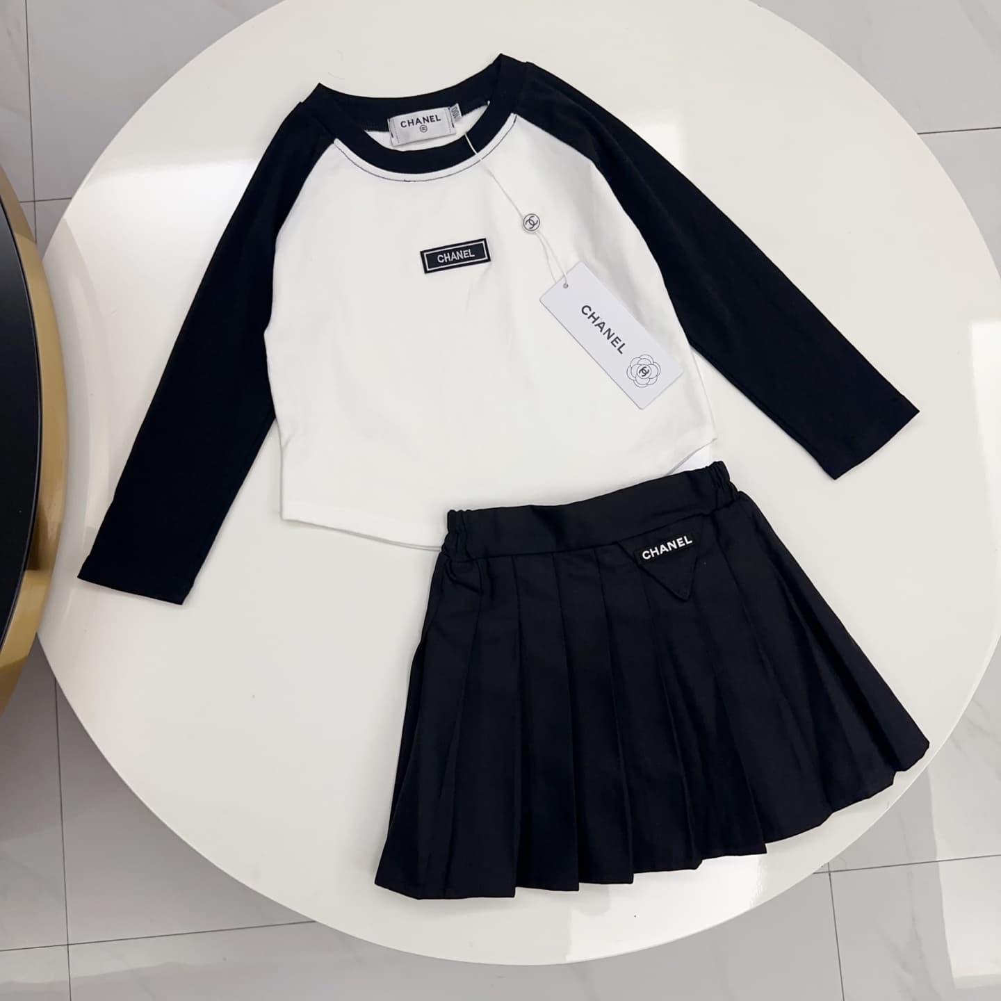 Ensemble deux pièces pour fille : haut à manches raglan contrastées et mini-jupe plissée.