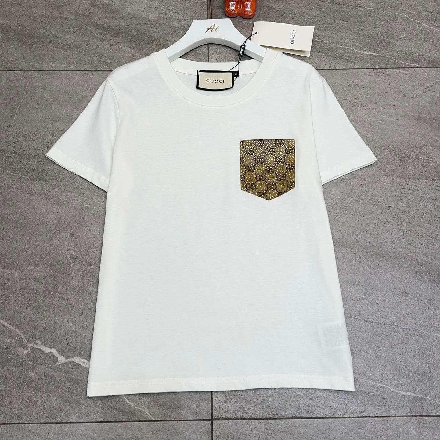Ensemble Gucci Été 2026 : T-shirt à manches courtes décontracté et résistant, jupe courte ornée de strass, deux pièces tendance.