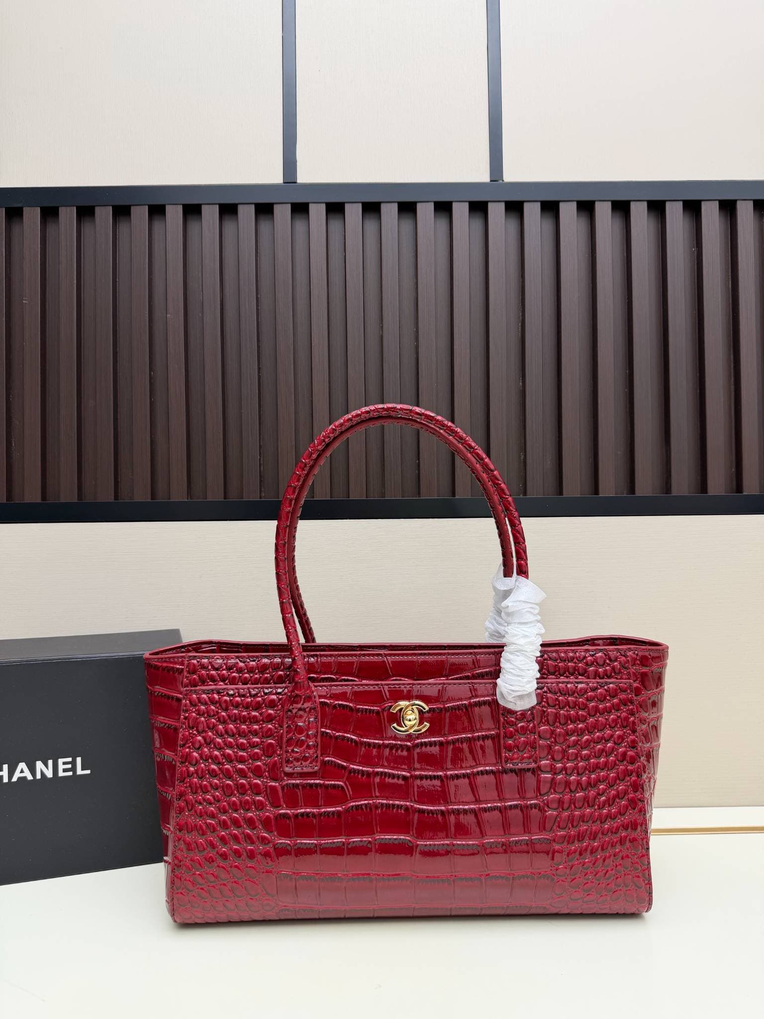 Sac cabas en cuir verni façon croco avec poignée supérieure ornée du logo en métal. Plusieurs couleurs. Grand format, idéal pour les trajets qu