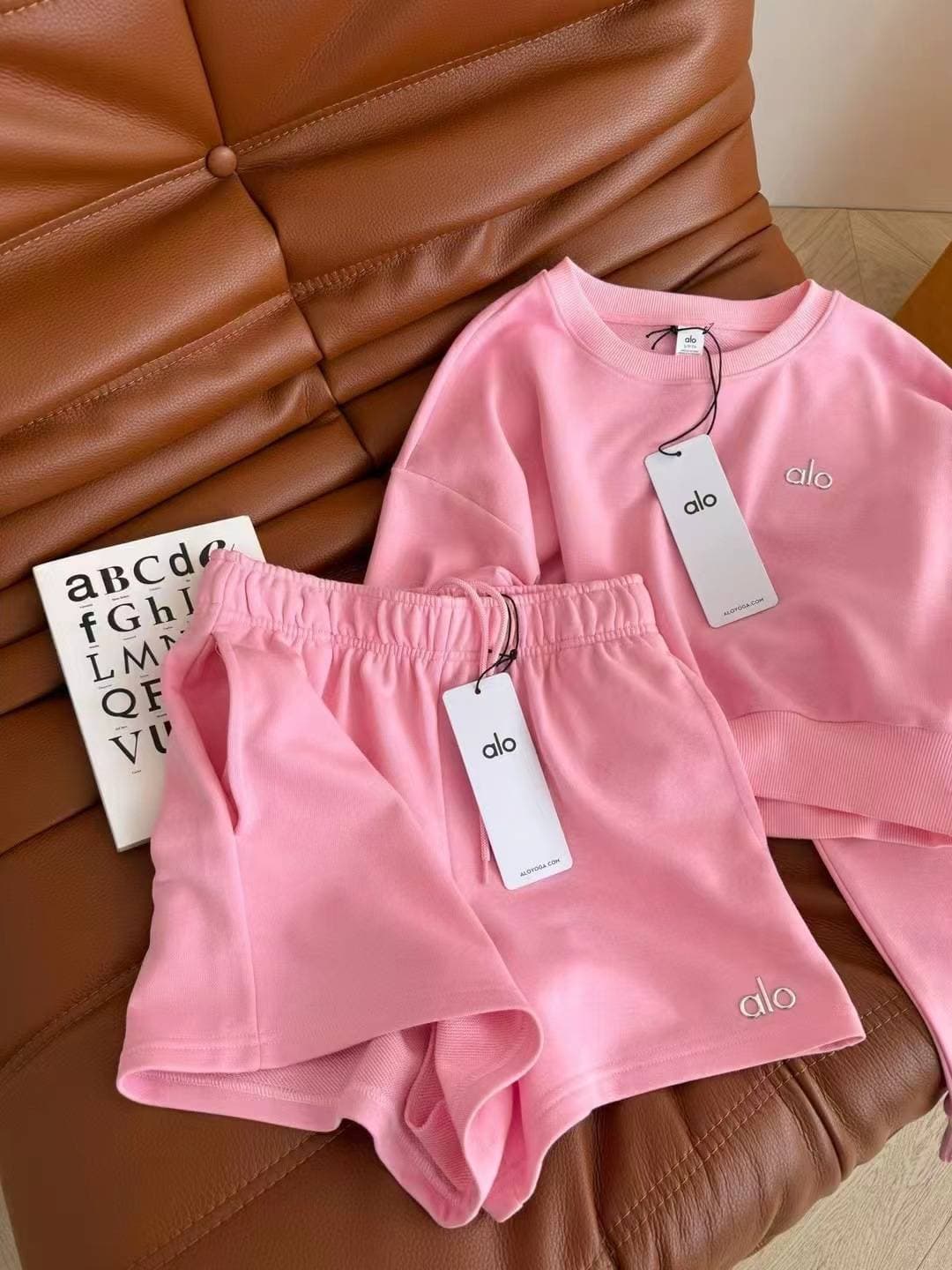 Ensemble coordonné pour femme en tissu doux rouge, composé d'un crop top à imprimé broderie Alo et d'un short décontracté à taille élastique.