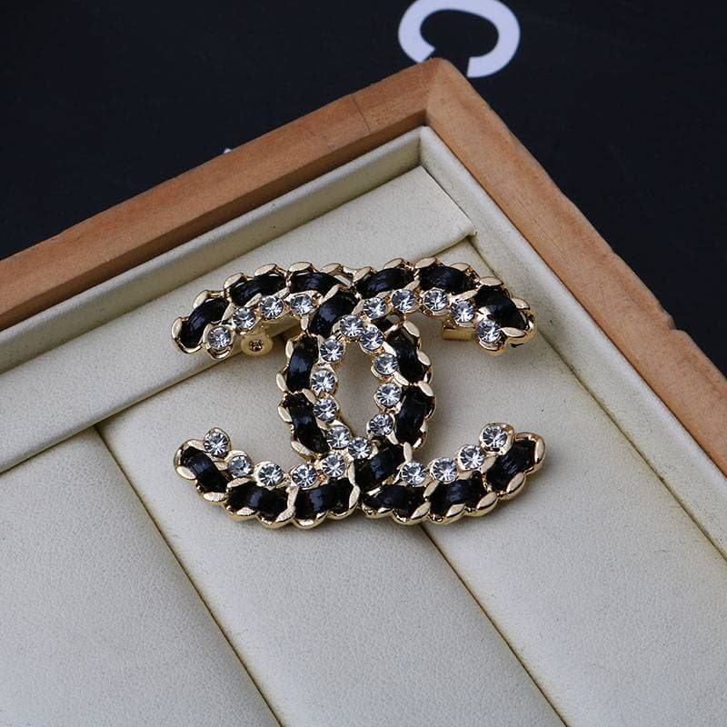 Broche en cuir et diamants, ornée de diamants, de qualité supérieure et portée à la main.