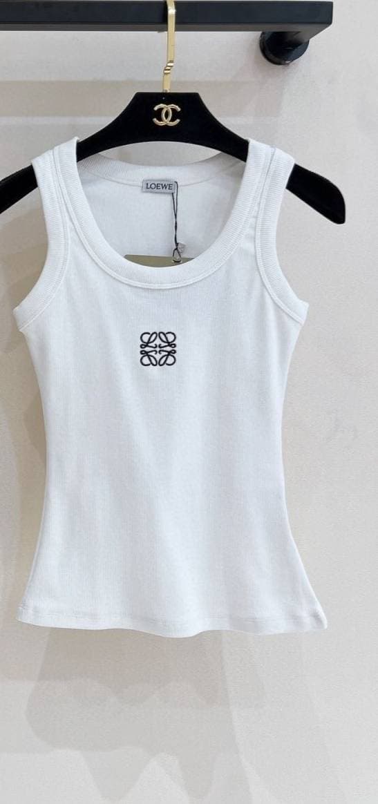 Gilet triangle printemps-été 2026 pour femme, 100% coton, coupe classique et ajustée, orné de détails métalliques.