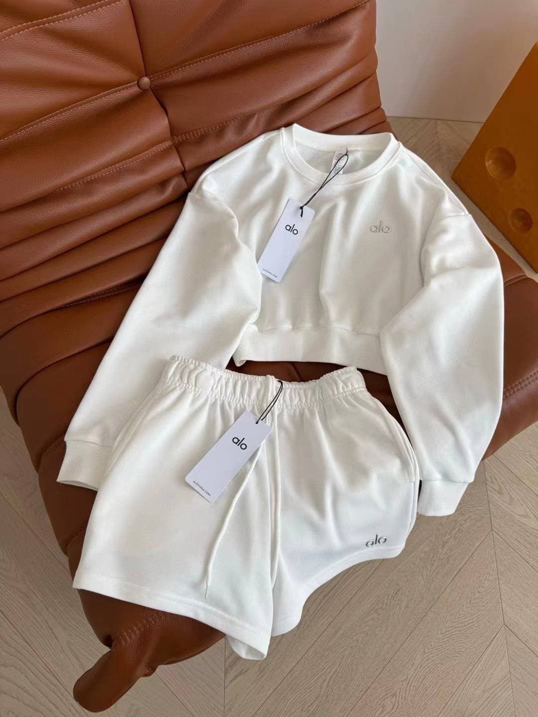 Ensemble coordonné pour femme en tissu doux rouge, composé d'un crop top à imprimé broderie Alo et d'un short décontracté à taille élastique.