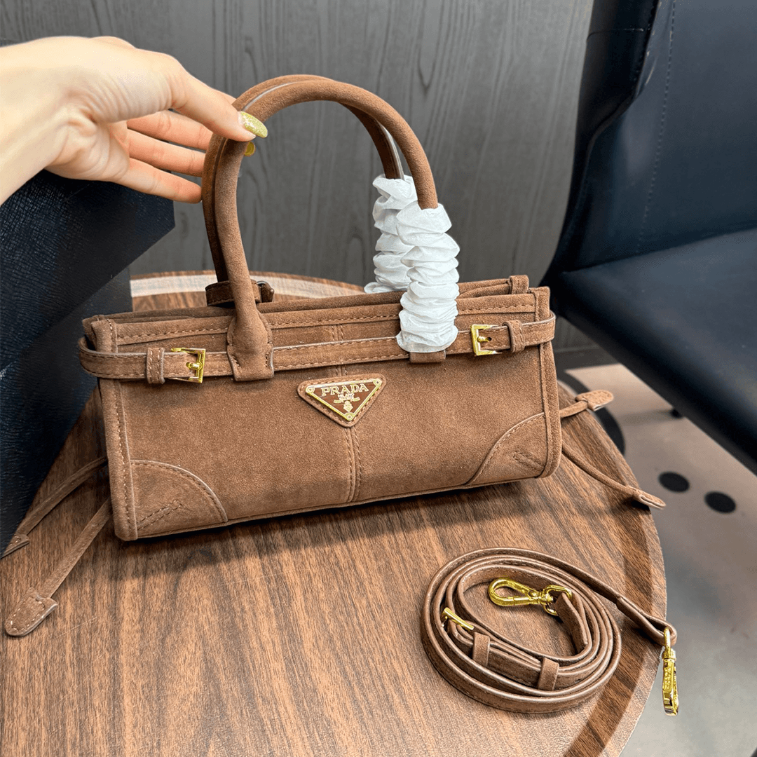 Sac à main Bonnie en daim marron, style vintage, avec insigne triangle doré, bandoulière amovible et porté épaule ou bandoulière.