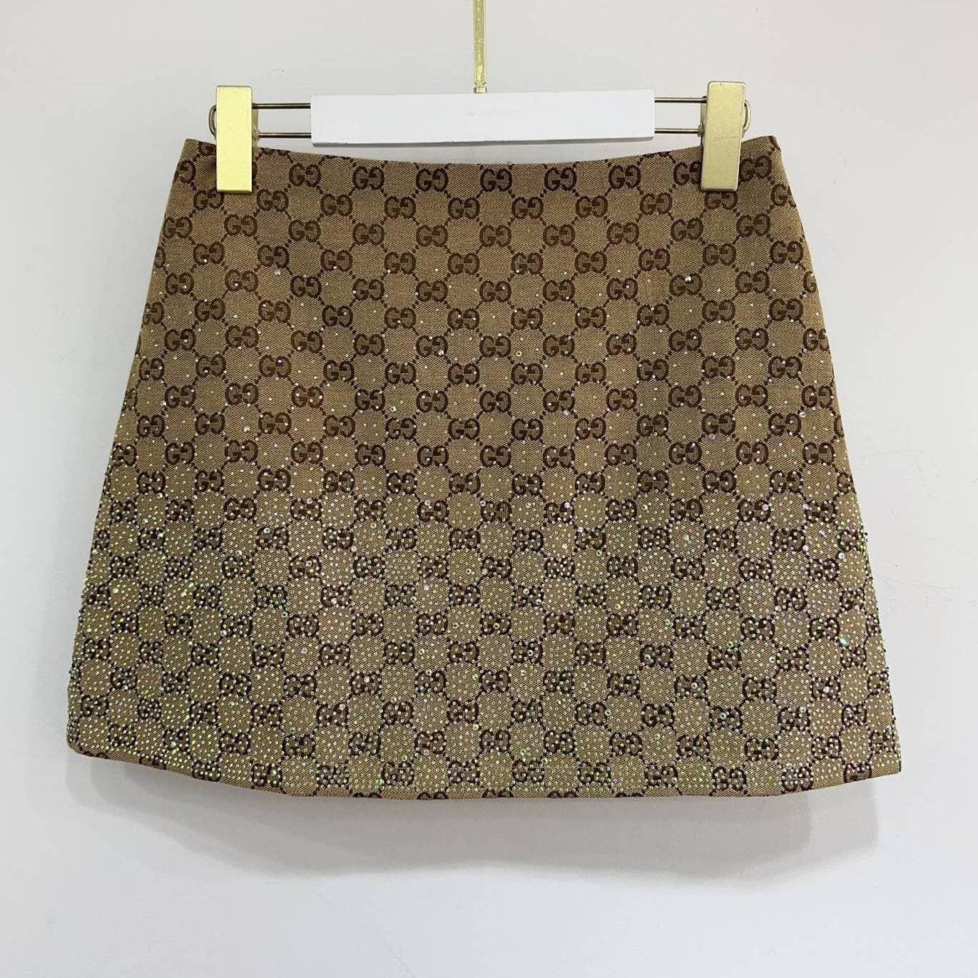 Ensemble Gucci Été 2026 : T-shirt à manches courtes décontracté et résistant, jupe courte ornée de strass, deux pièces tendance.