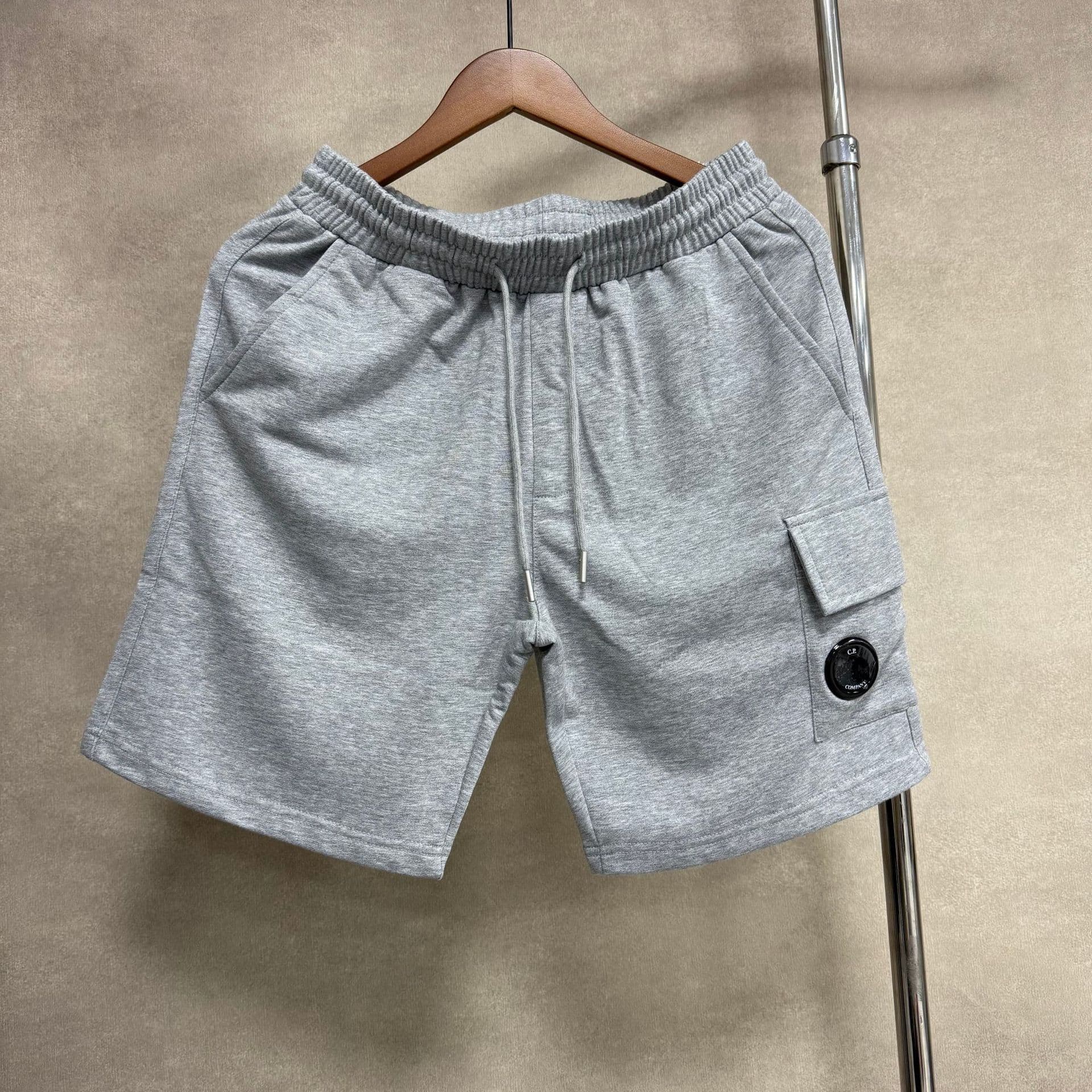 Short CP uni à manches courtes, style basique, avec badge, lentille, cordon de serrage et grande poche.