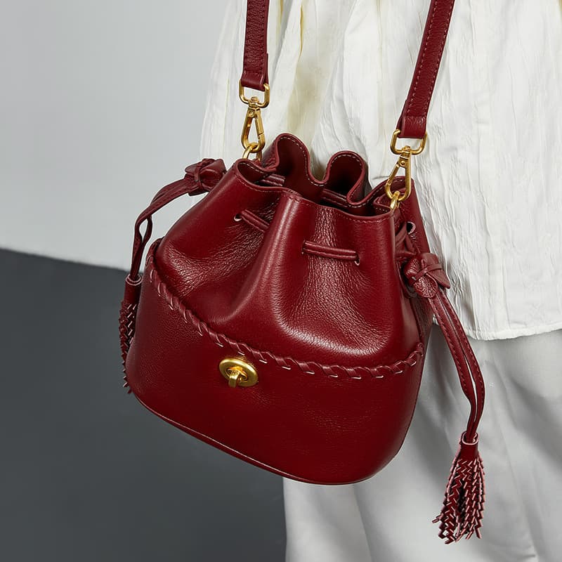 KOSE Sac seau en cuir de vachette de première qualité, nouveau sac en cuir véritable pour femme, sac messager à bandoulière avec cordon de serrage et pompon