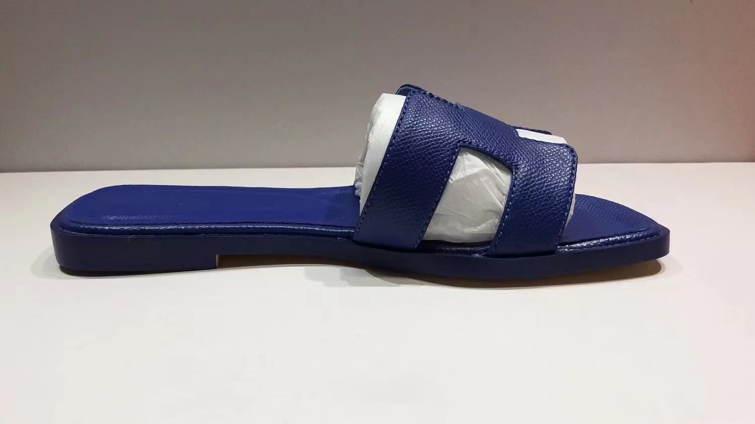 Les femmes portent du cuir avec des pantoufles plates et des sandales