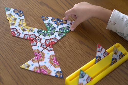 TRIOMINOS Junior - Edition Pat' Patrouille - Jeu de Dominos pour Enfants dès 3 Ans - Dominos à 3 côtés - Jeu d'Observation & Association - Double Face Triominos ou Puzzle - 1 à 4 Joueurs - 20 Min