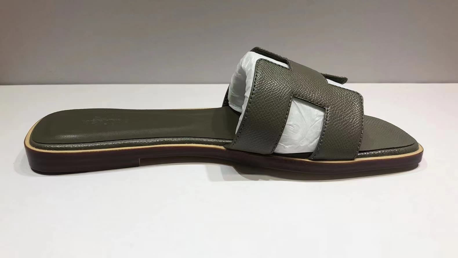 Les femmes portent du cuir avec des pantoufles plates et des sandales