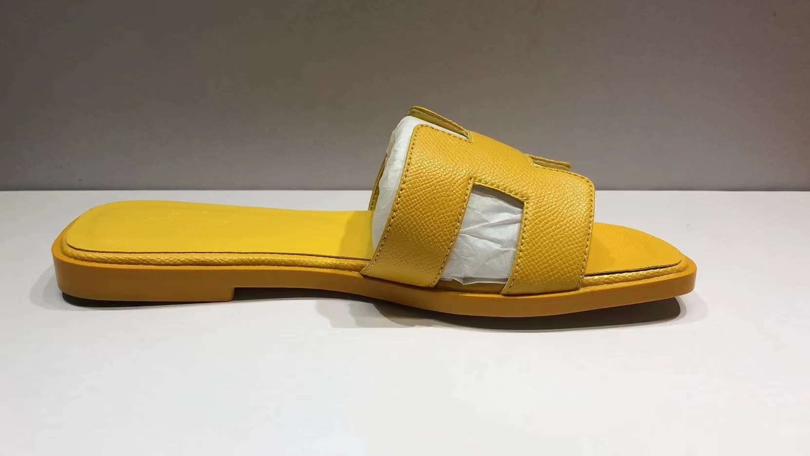 Les femmes portent du cuir avec des pantoufles plates et des sandales